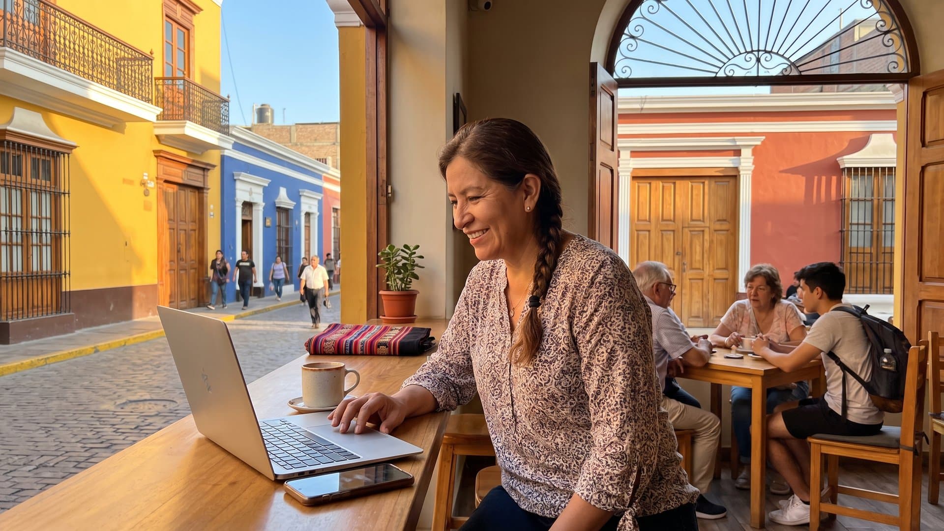 Dueña de una cafetería configura todo en su laptop mientras el teléfono se ilumina en el mostrador
